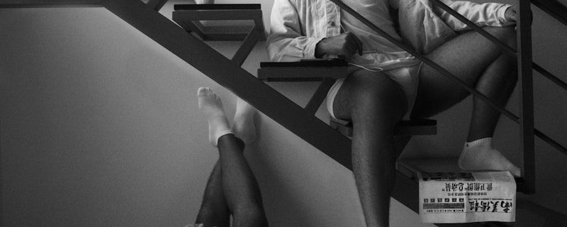 man in white shirt and black shorts sitting on black metal frame